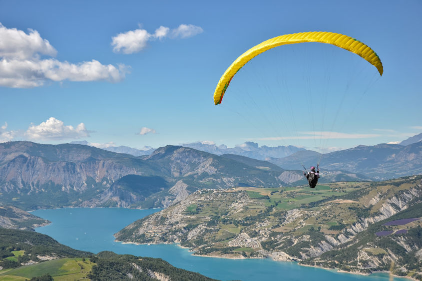 Alone in the Sky Portrait d'un parapentiste avec vue sur le lac de Serre-Ponçon